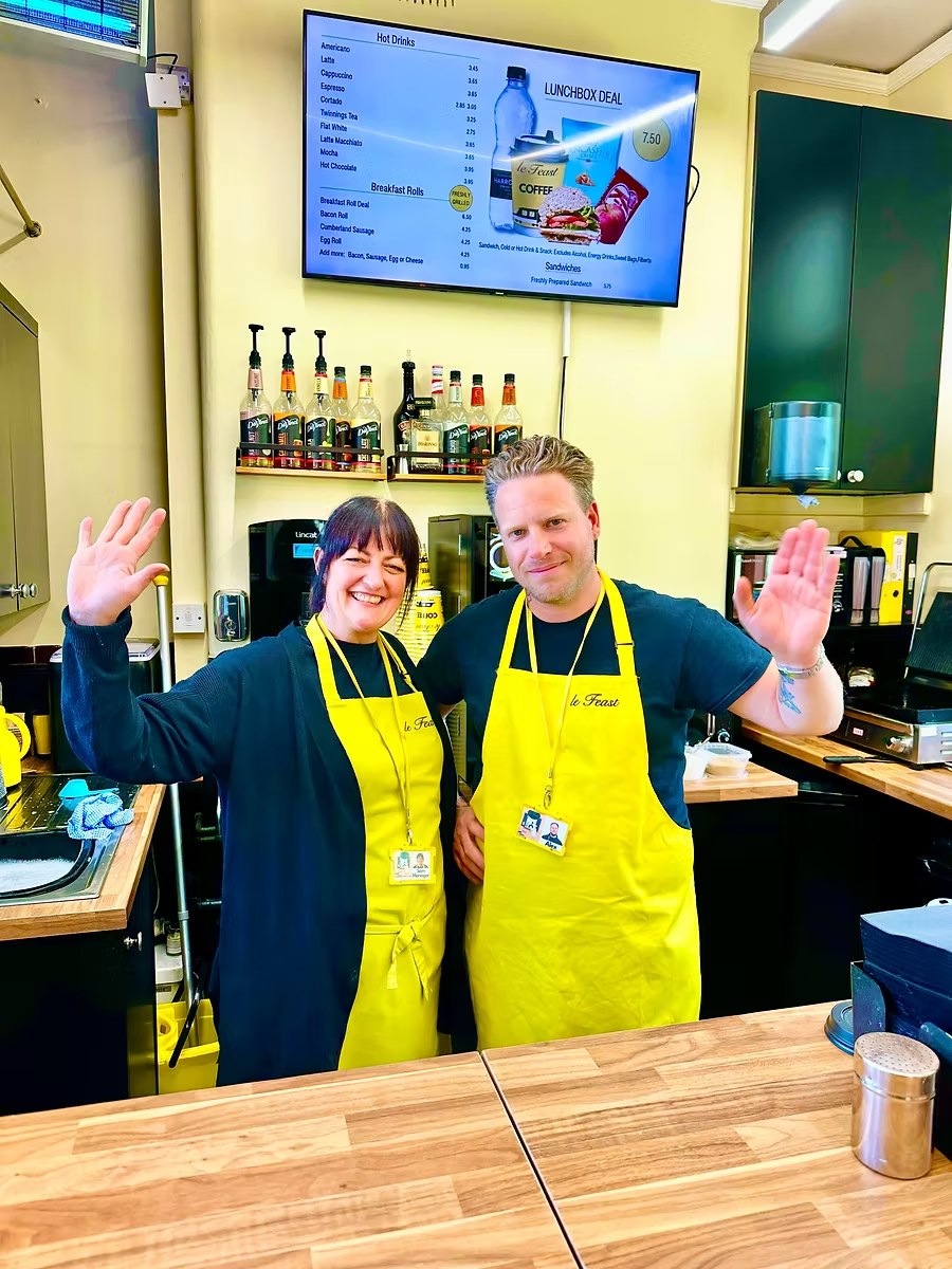 Le Feast team serving customers at a North West station cafe Le Feast team members serving customers at a yellow station cafe counter